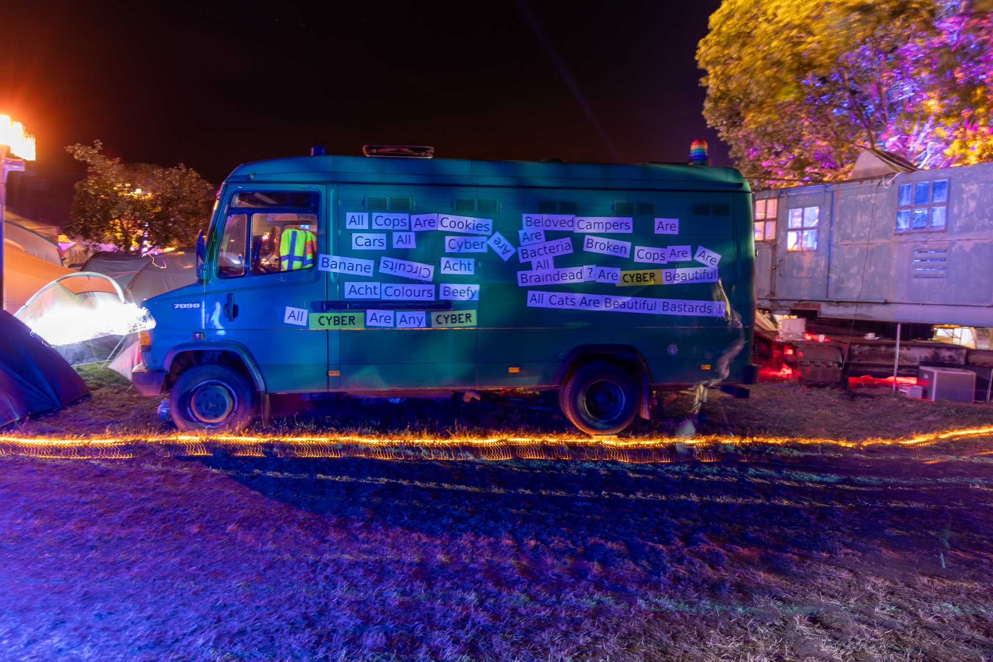 magnets on a green van, spelling out slogans with ghosts of people slightly visible