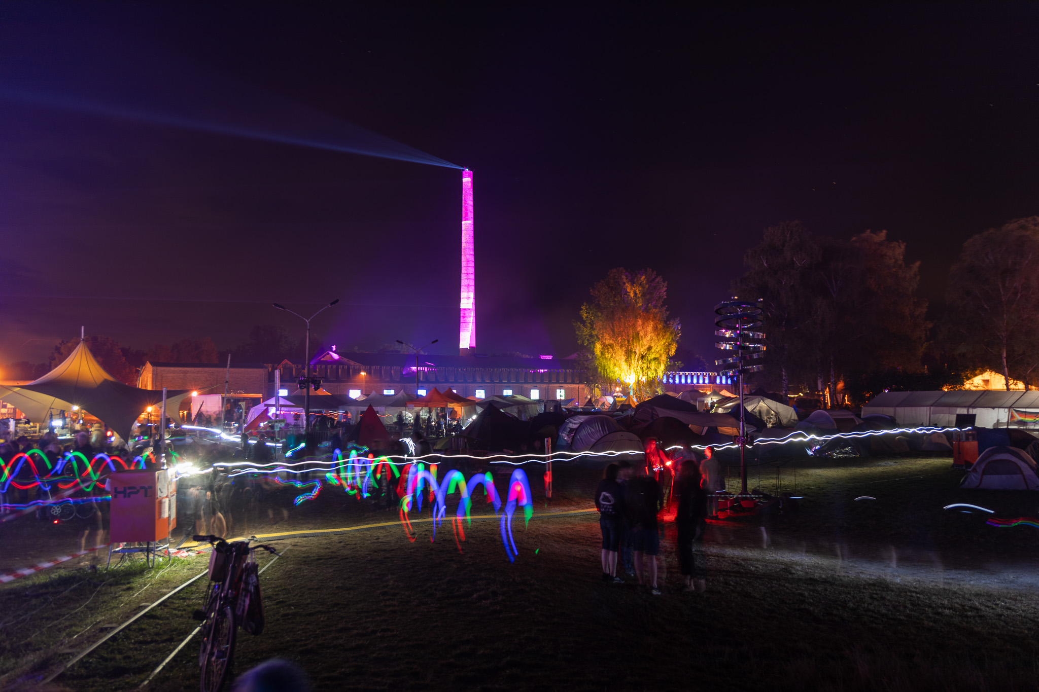 traces of bicycles with flashing LEDs pass crowds of people